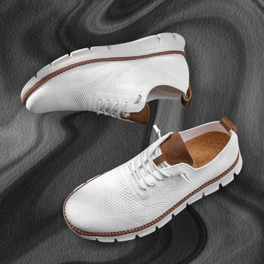 Zapatillas de senderismo blancas con cordones, paneles texturizados y suela dentada.