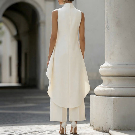 Mono elegante blanco sin mangas con cuello alto, espalda y abertura frontal drapeada