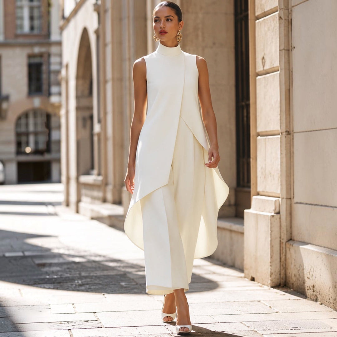 Mono elegante blanco con cuello alto, top drapeado asimétrico y pantalón ancho hasta el tobillo