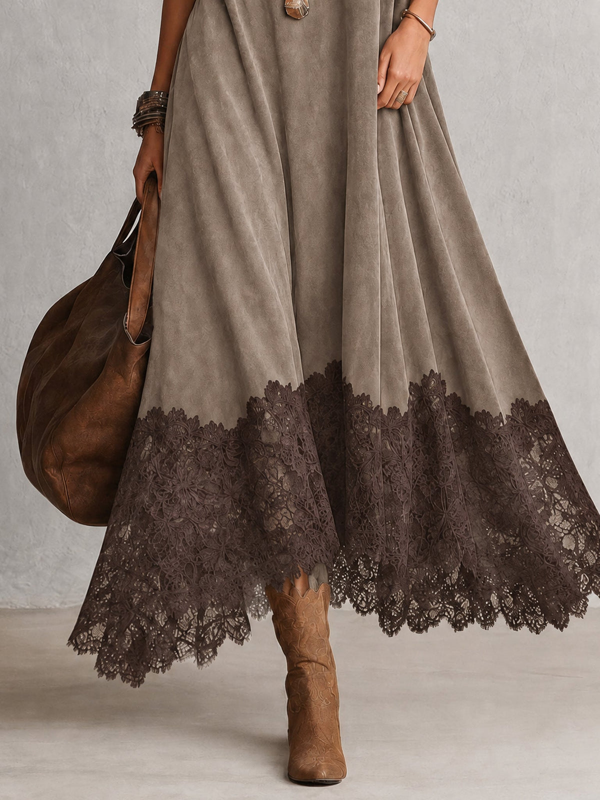 Detalle del bajo de encaje oscuro en el vestido largo gris efecto ante