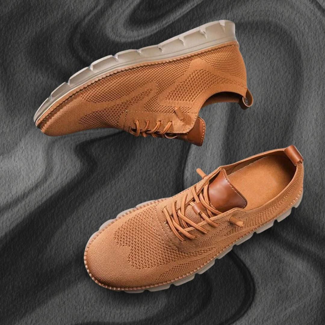 Zapatilla de senderismo marrón claro con cordones y suela blanca dentada.
