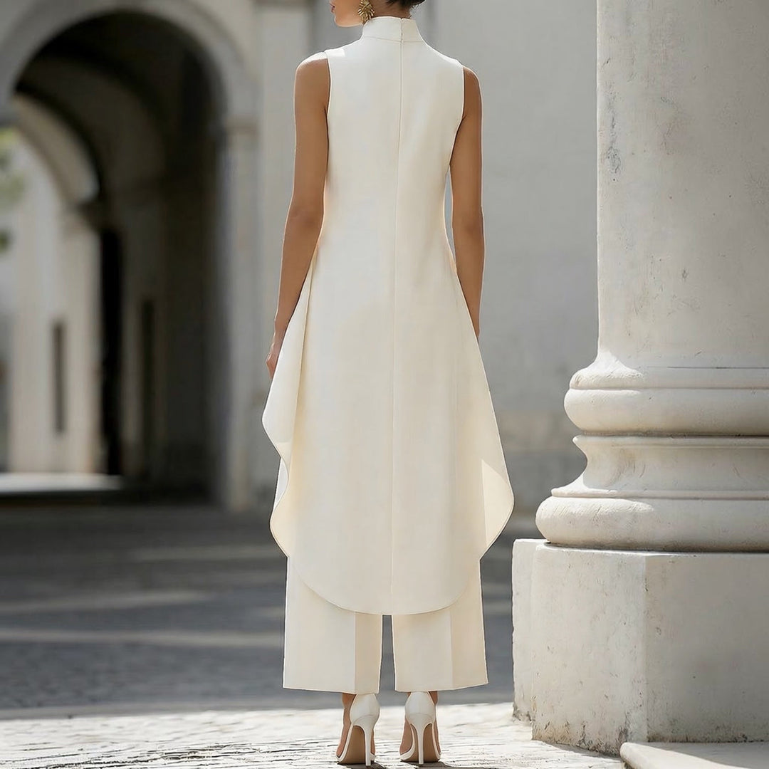 Mono elegante blanco sin mangas con cuello alto, espalda y abertura frontal drapeada