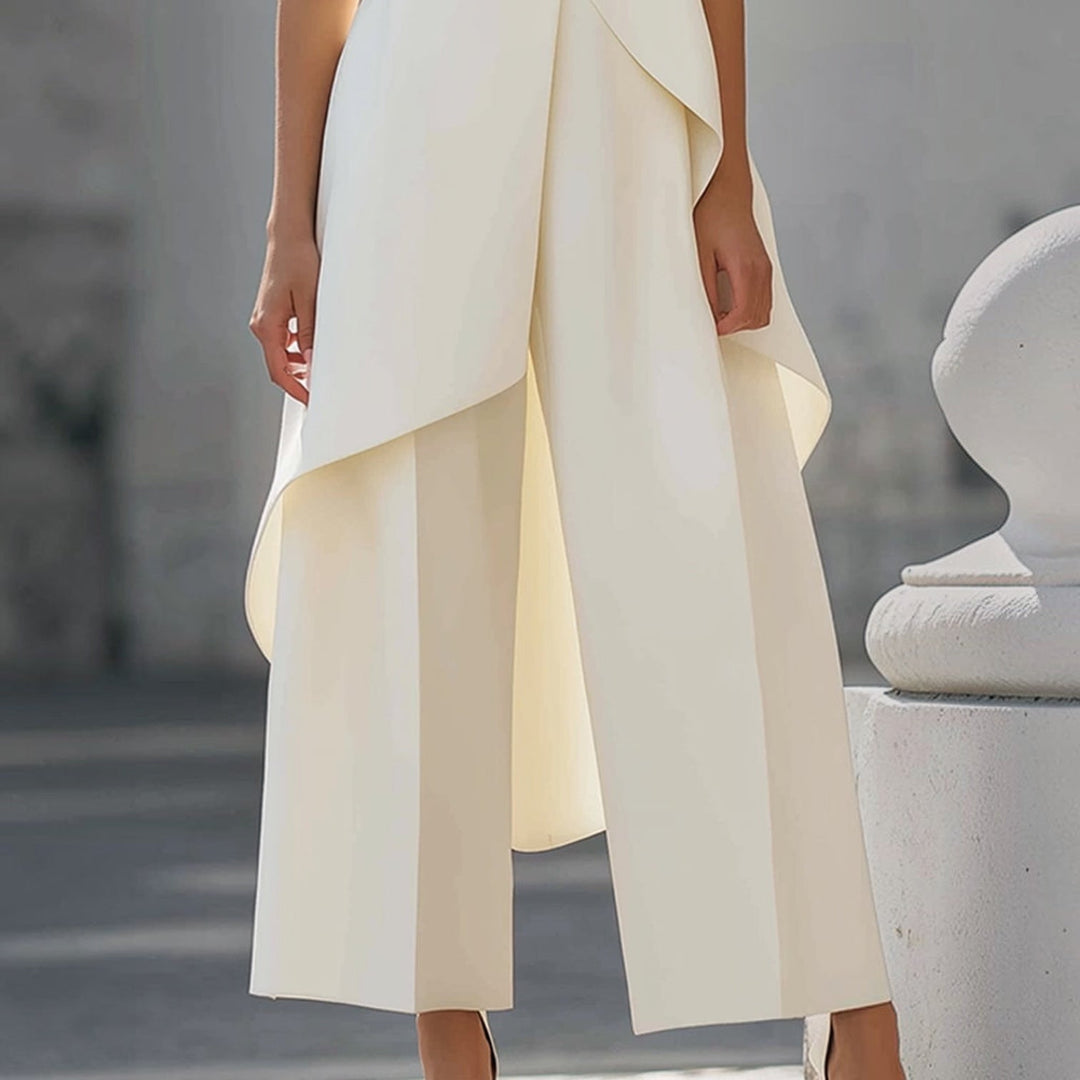 Mono elegante blanco con pantalón ancho y caídas asimétricas del top drapeado