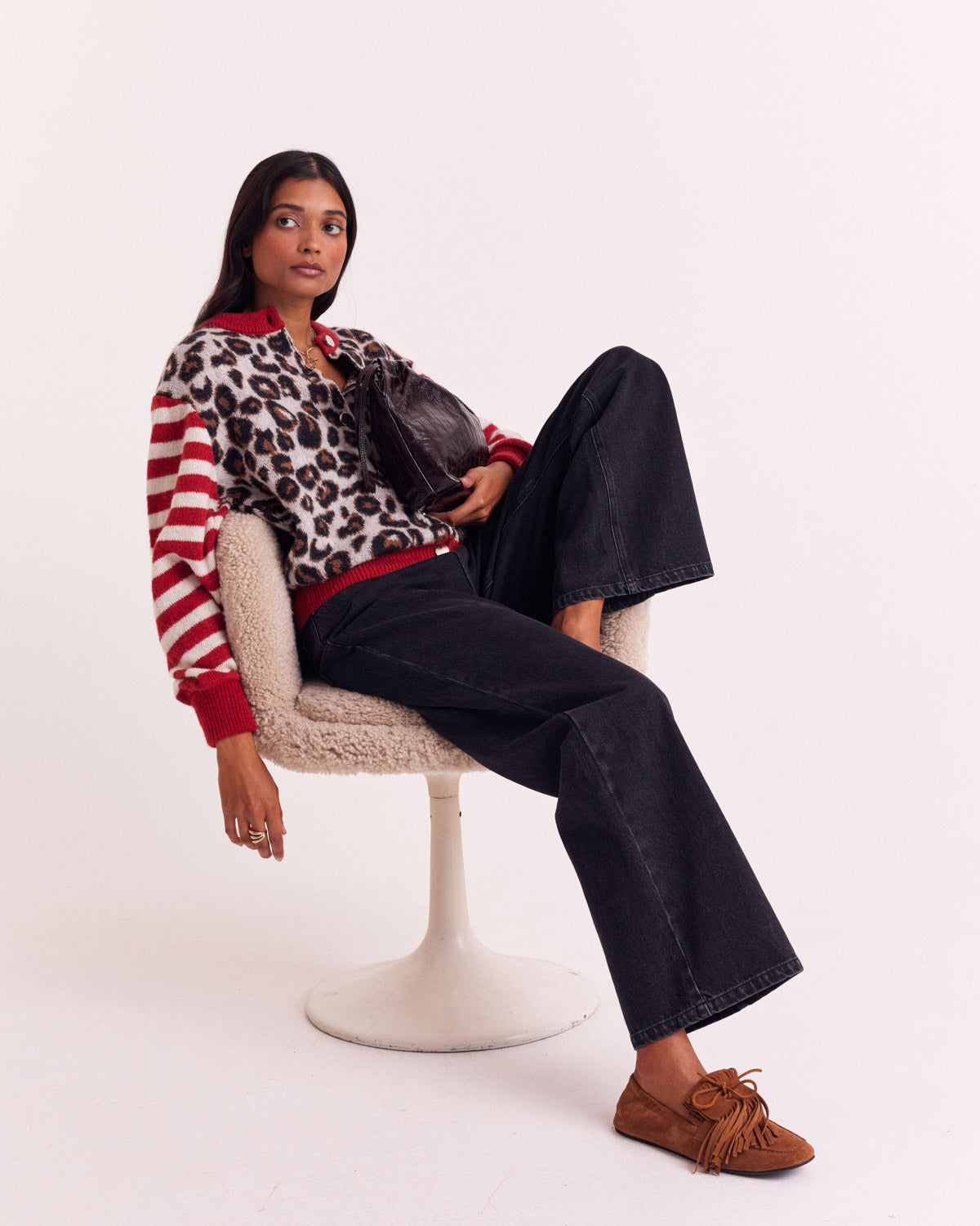 Cárdigan de leopardo con mangas a rayas rojas y blancas, combinado con vaqueros oscuros