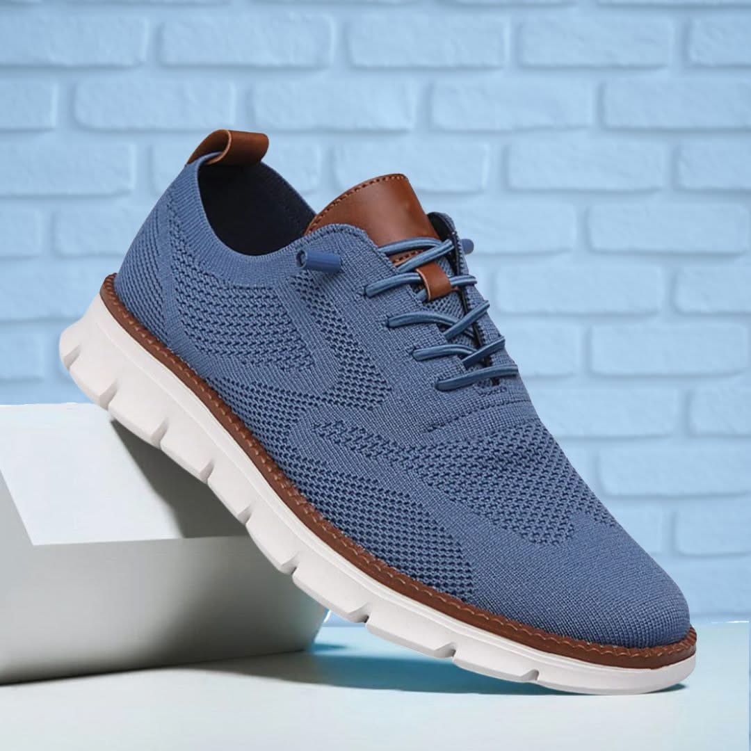 Zapatilla de senderismo azul con cordones, paneles de malla y suela dentada.