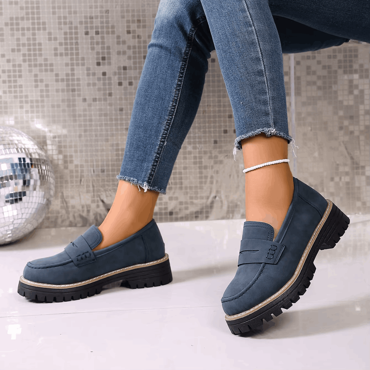 Mocasines con plataforma azul marino de estilo universitario, suela dentada y borde claro.
