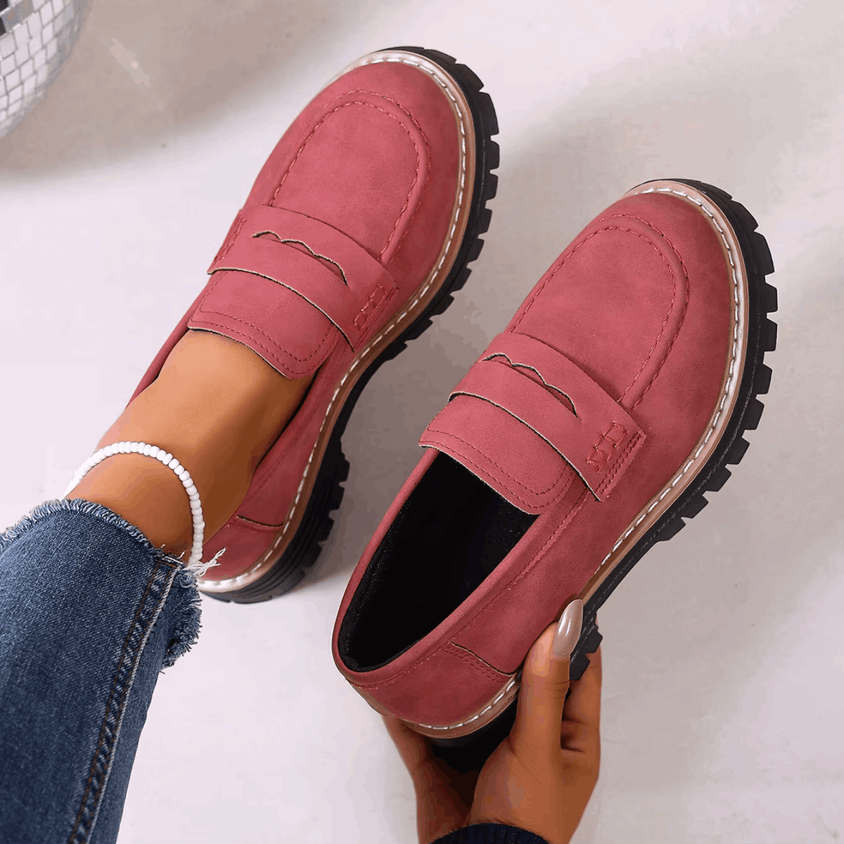 Mocasines con plataforma burdeos con costuras visibles y suela dentada gruesa.