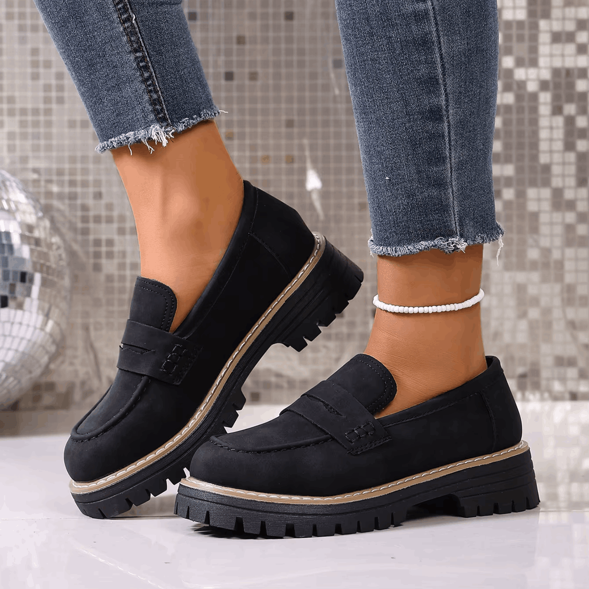 Mocasines con plataforma negros, tira frontal y suela dentada con ribete claro.