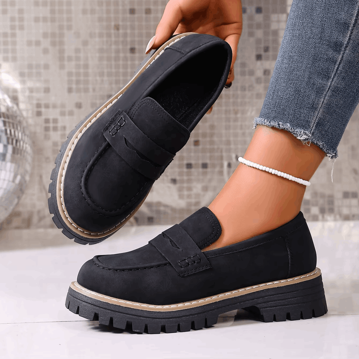 Mocasines con plataforma negros con hebilla frontal y suela dentada robusta.