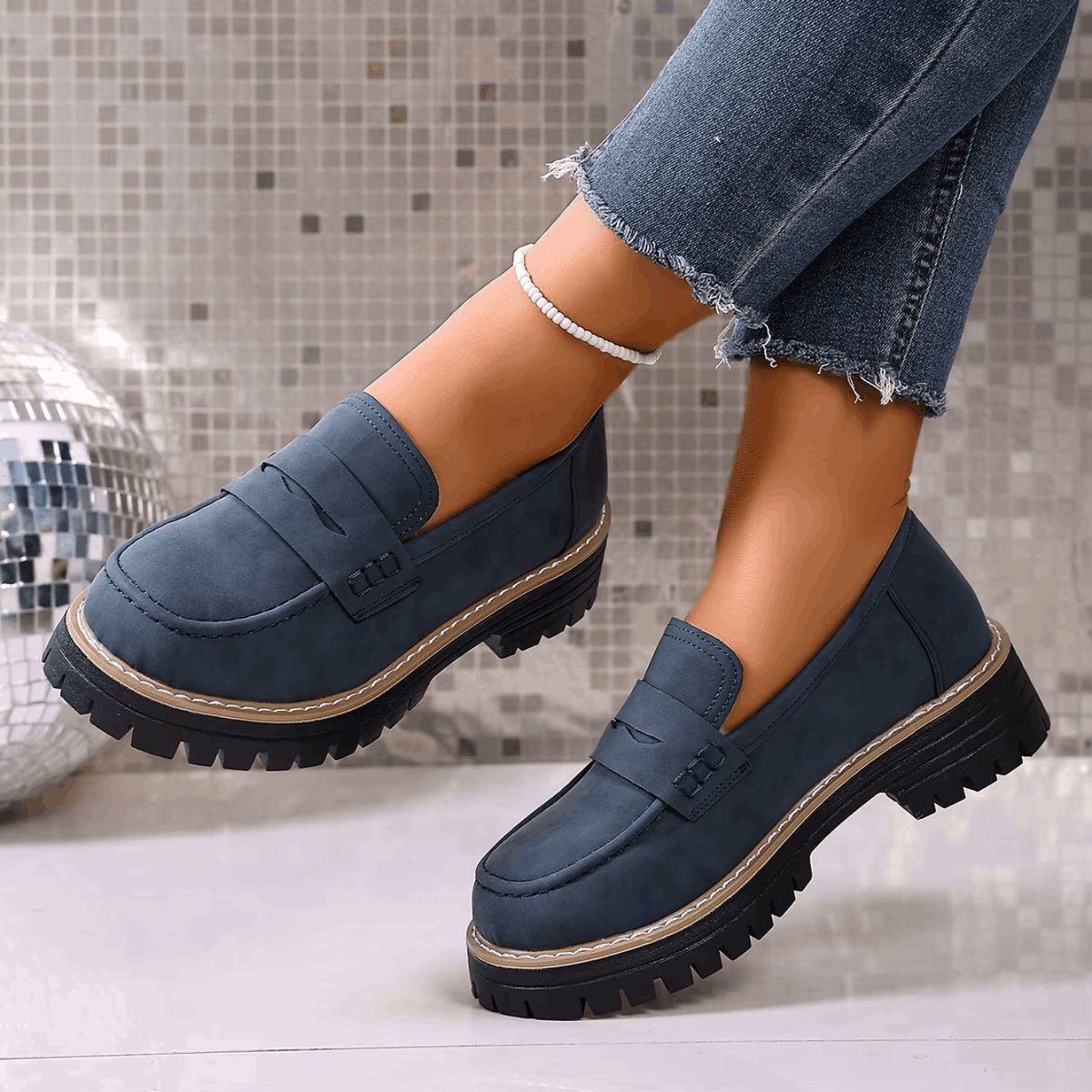 Mocasines con plataforma azul marino con hebilla frontal y suela dentada negra.