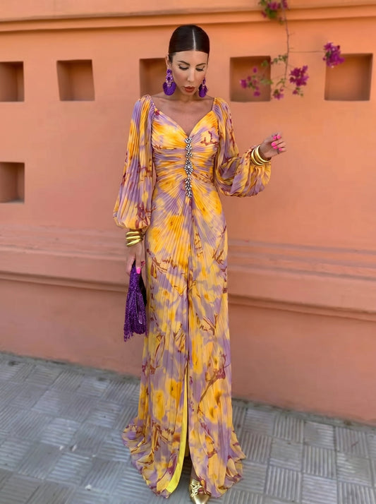 Vestido largo amarillo y lila con estampado floral, escote pronunciado y mangas globo.