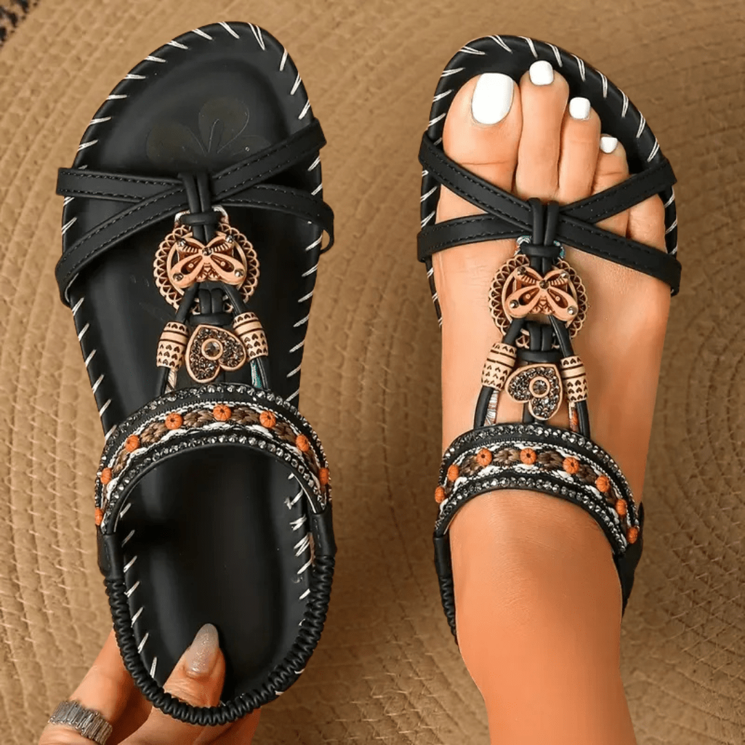 Sandalias estilo Ibiza negras con tiras y adorno colgante dorado en la parte frontal